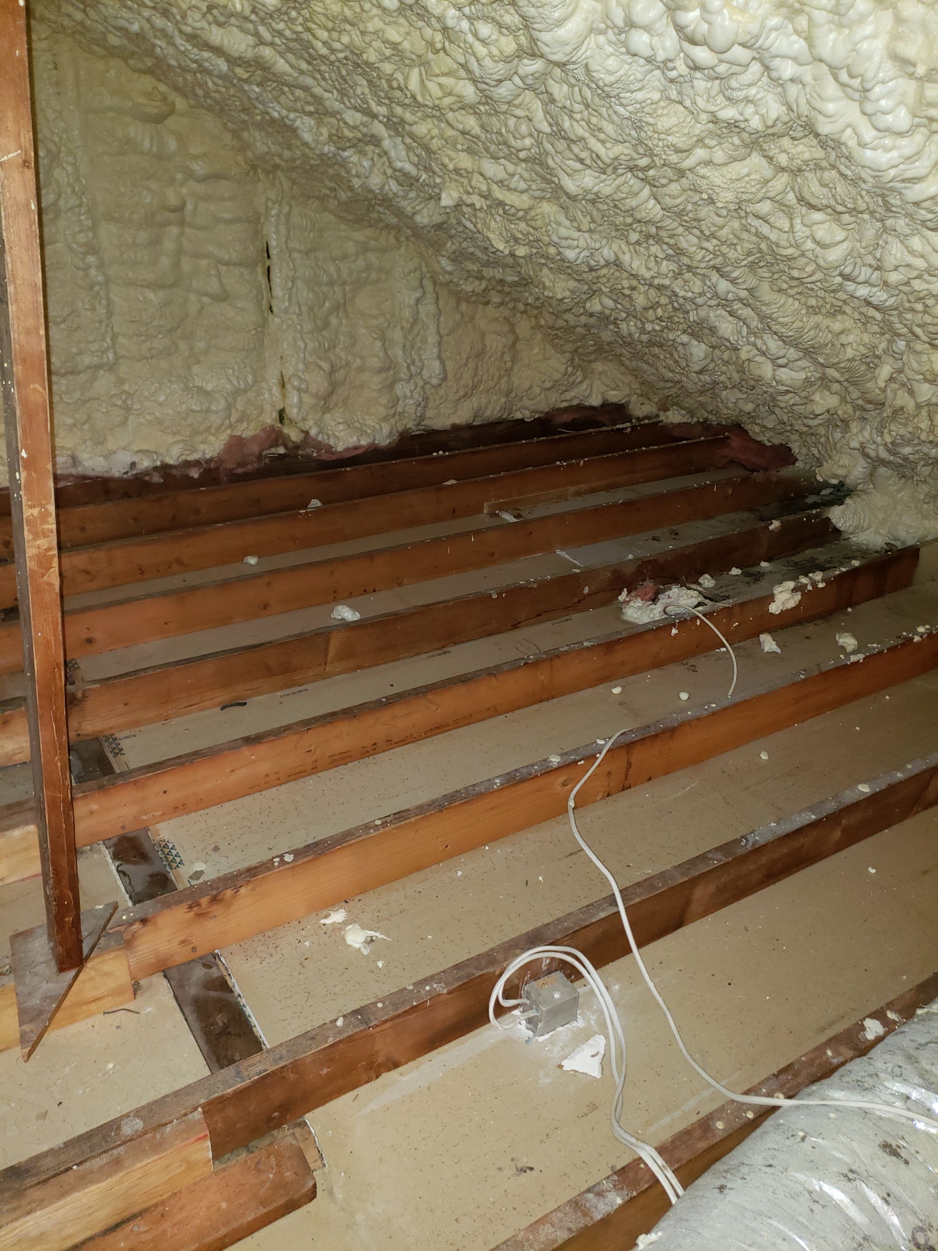 A room with wooden beams and foam on the ceiling.