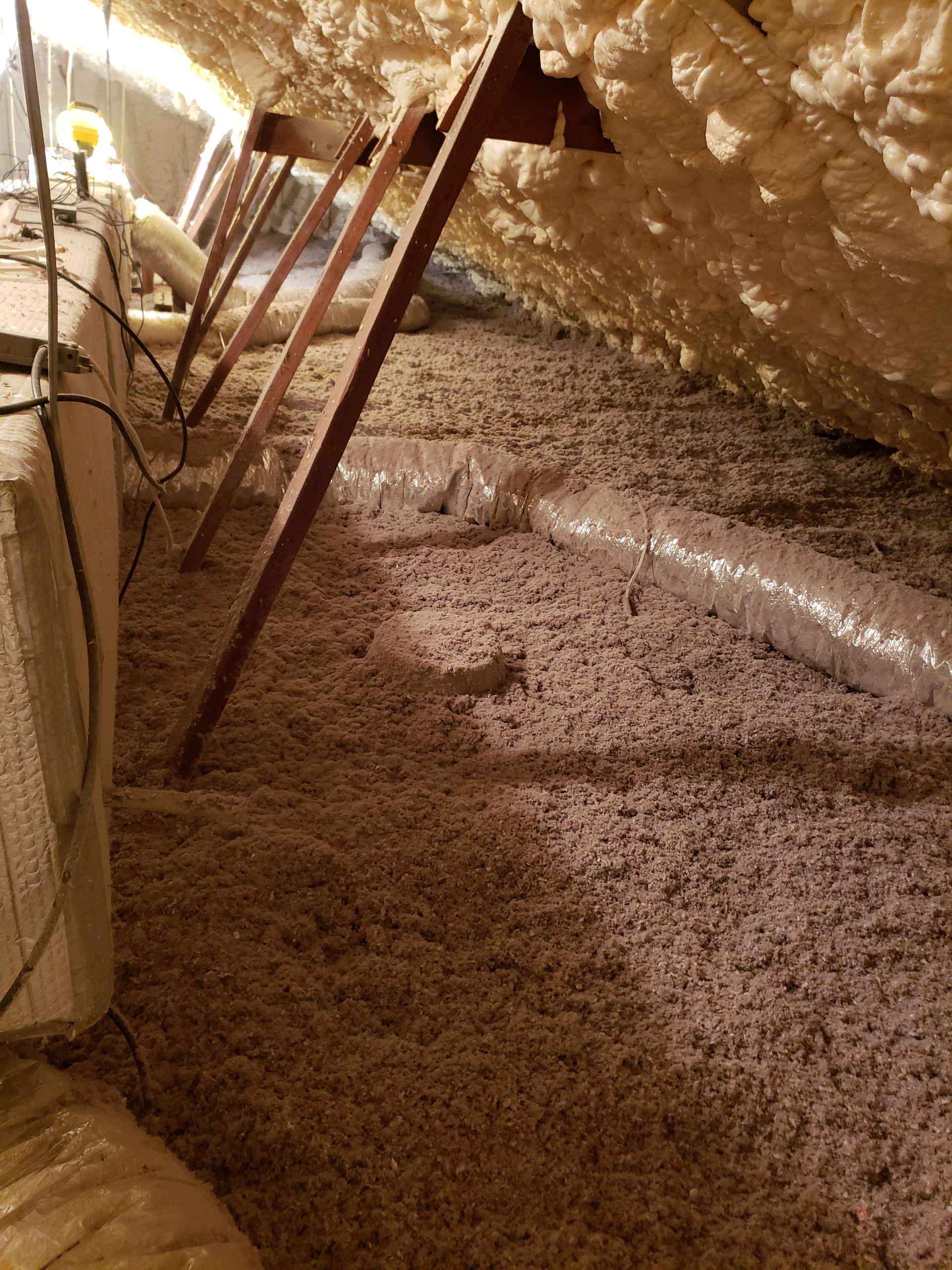 There is a lot of insulation in the attic of a house.