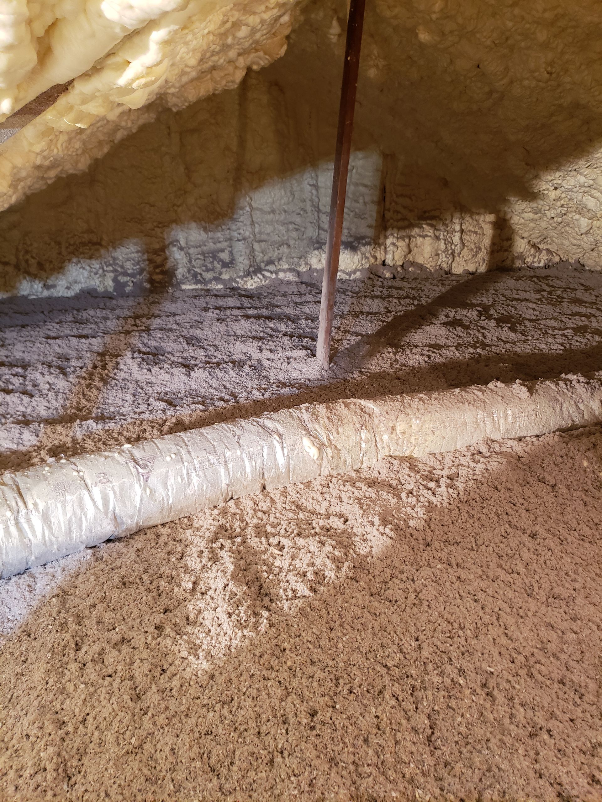 There is a pipe in the attic with a lot of insulation.