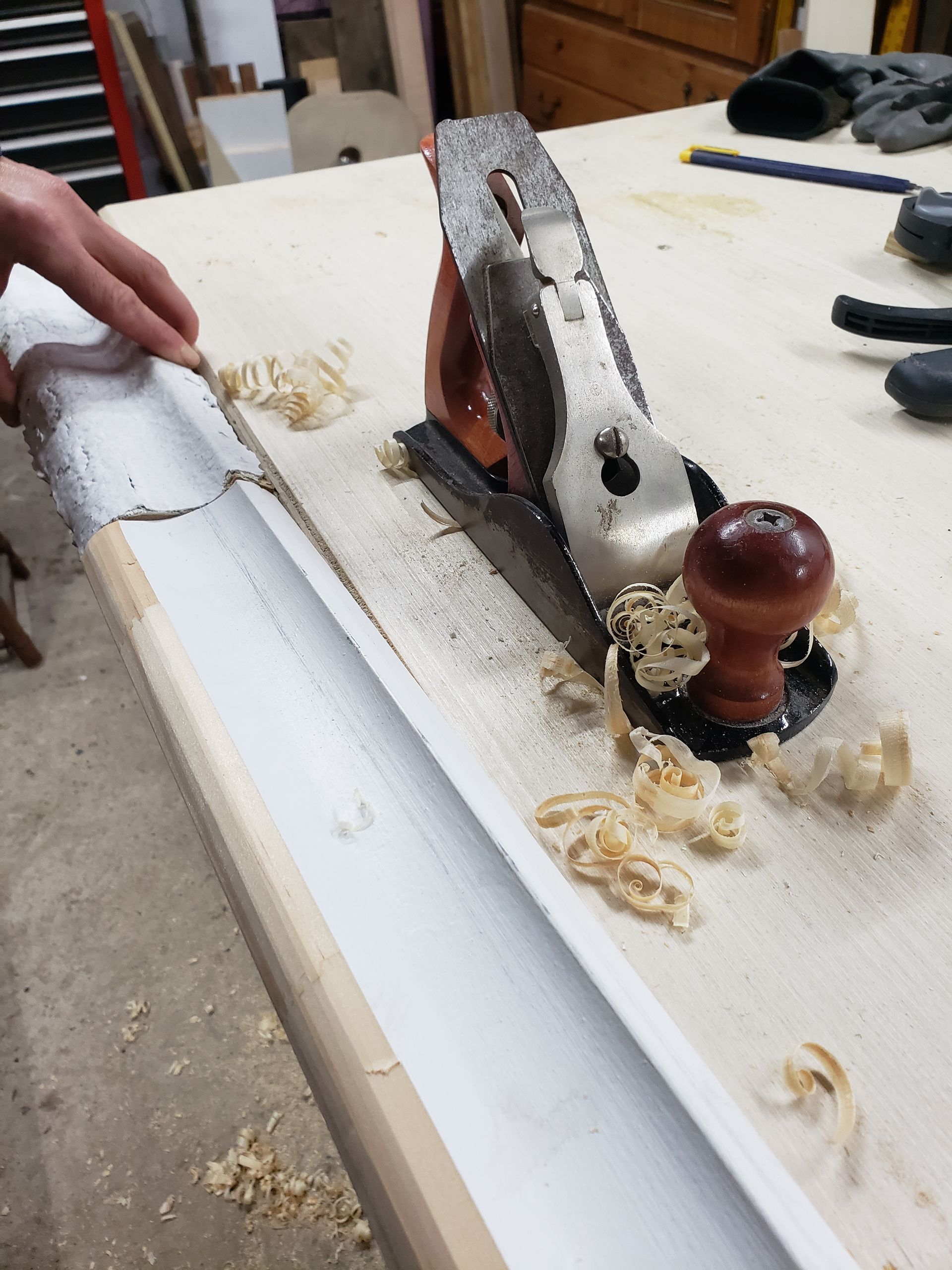 A person is using a plane on a piece of wood