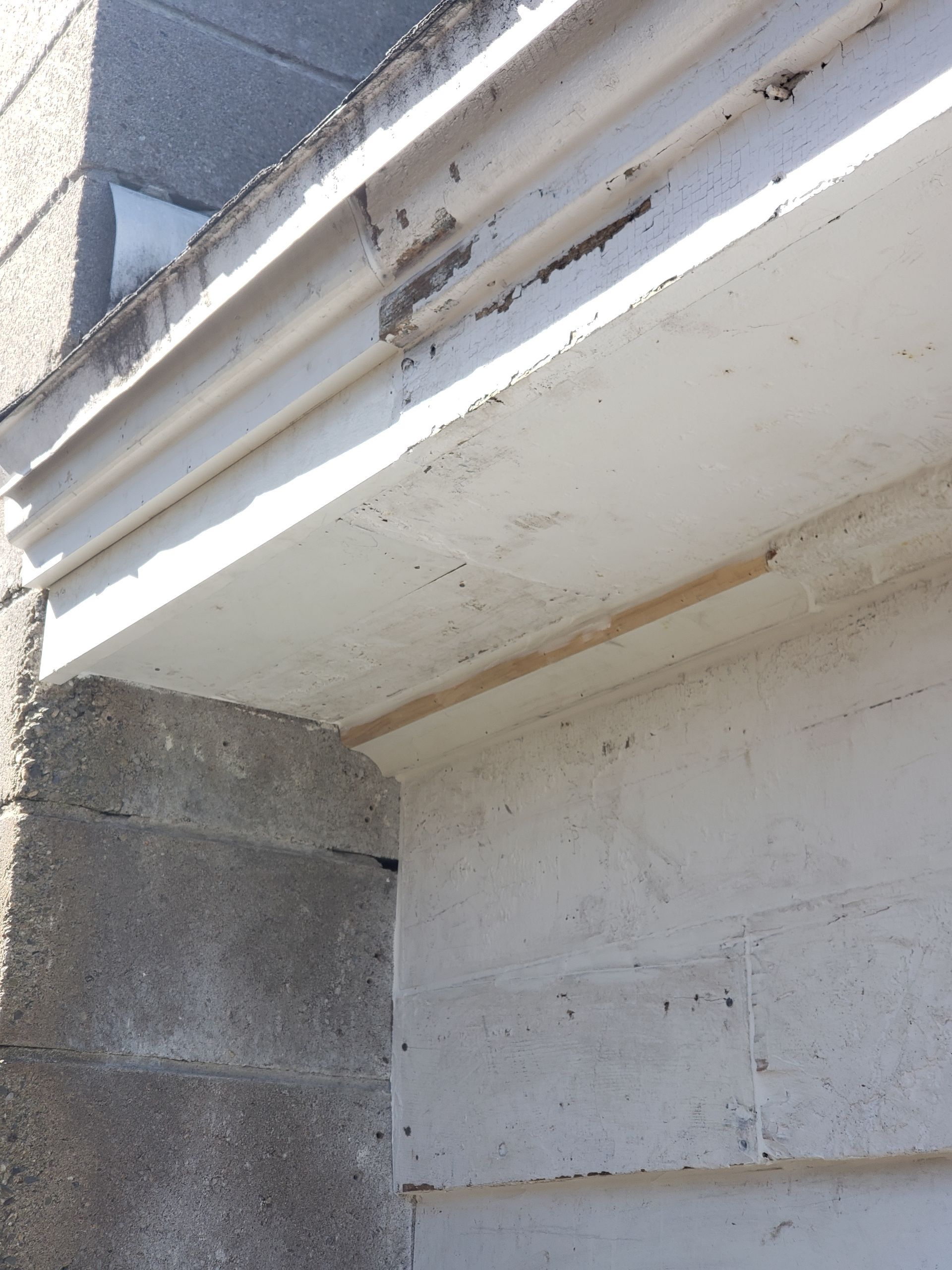 A white gutter on the side of a building
