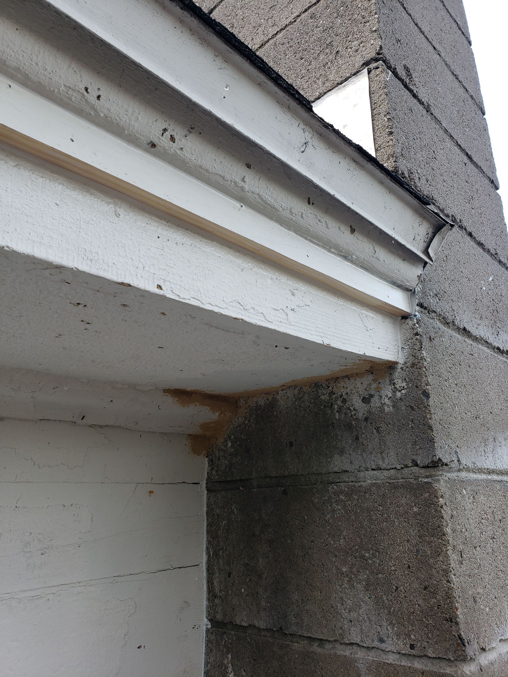 A close up of a white trim on a brick wall