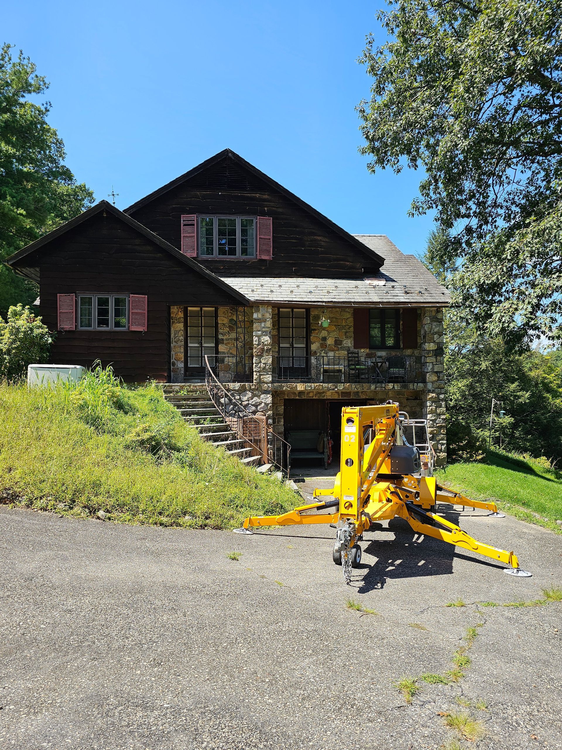 A yellow crane is parked in front of a house.