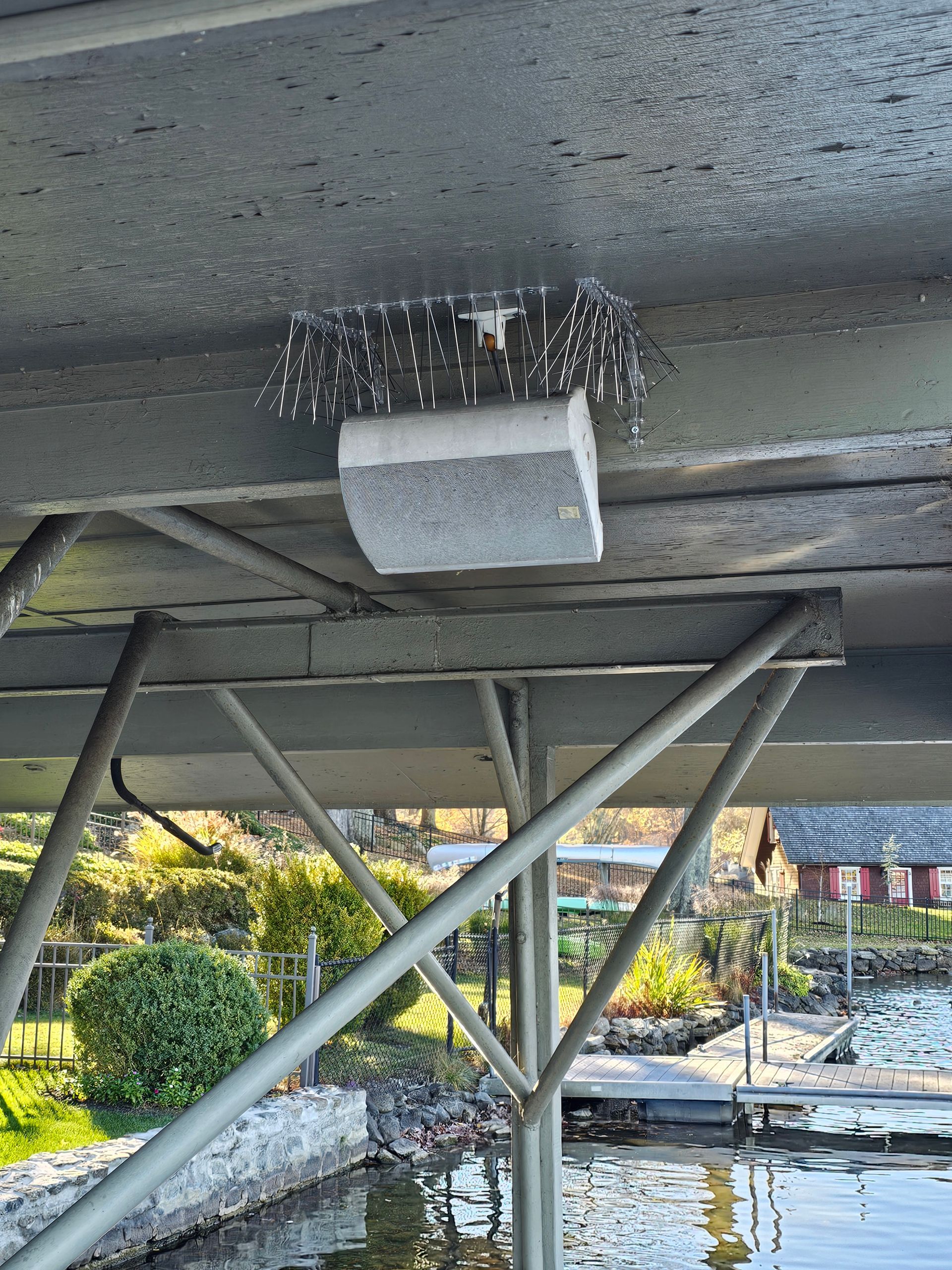 A brush is hanging from the ceiling of a boat dock.