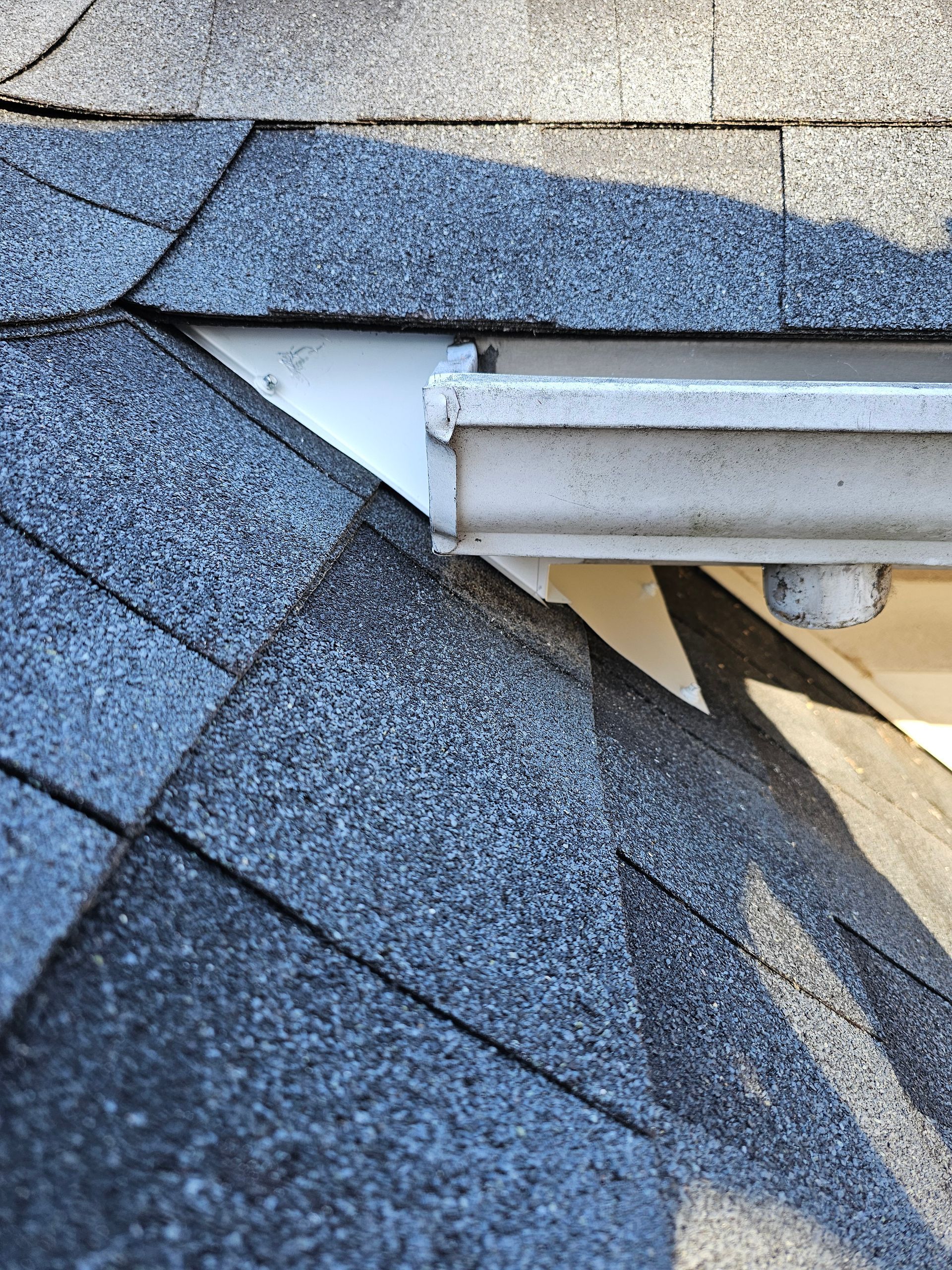 A close up of a gutter on a roof of a house.