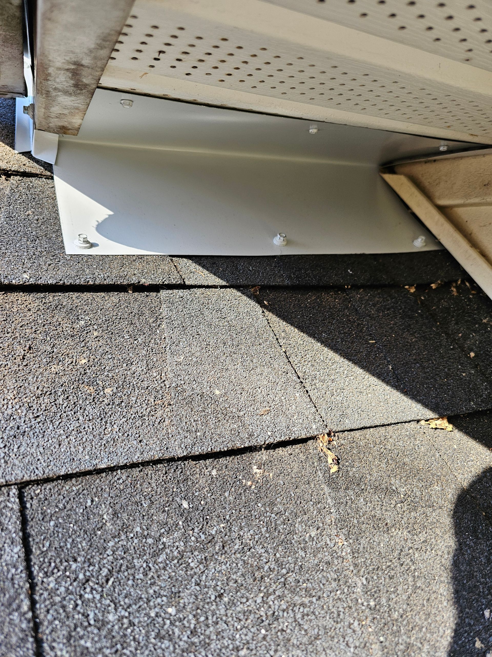 A close up of a roof with a white gutter on it.