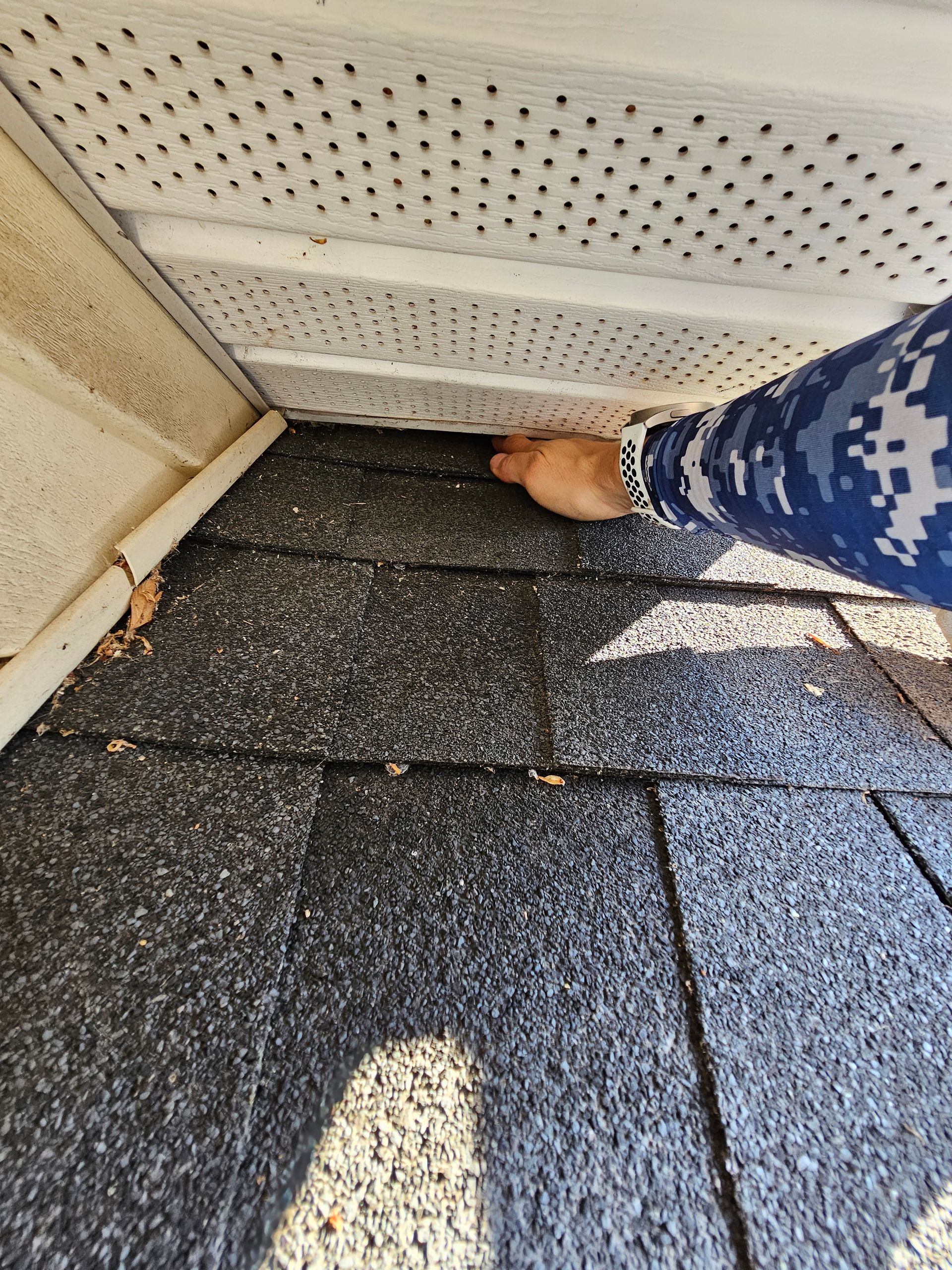 A person is standing on a roof with their feet on it.