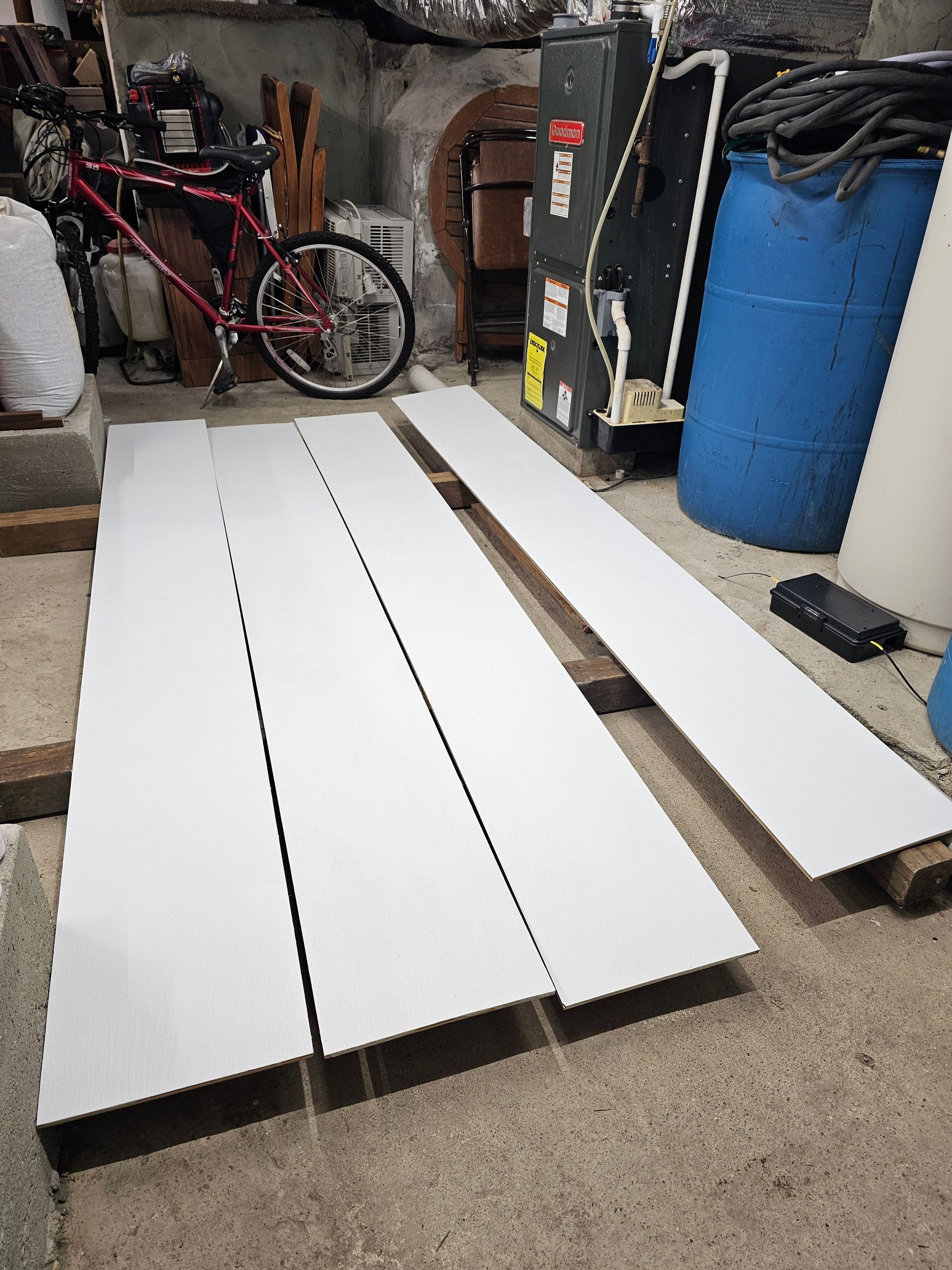 A bicycle is parked in a garage next to a bunch of barrels.