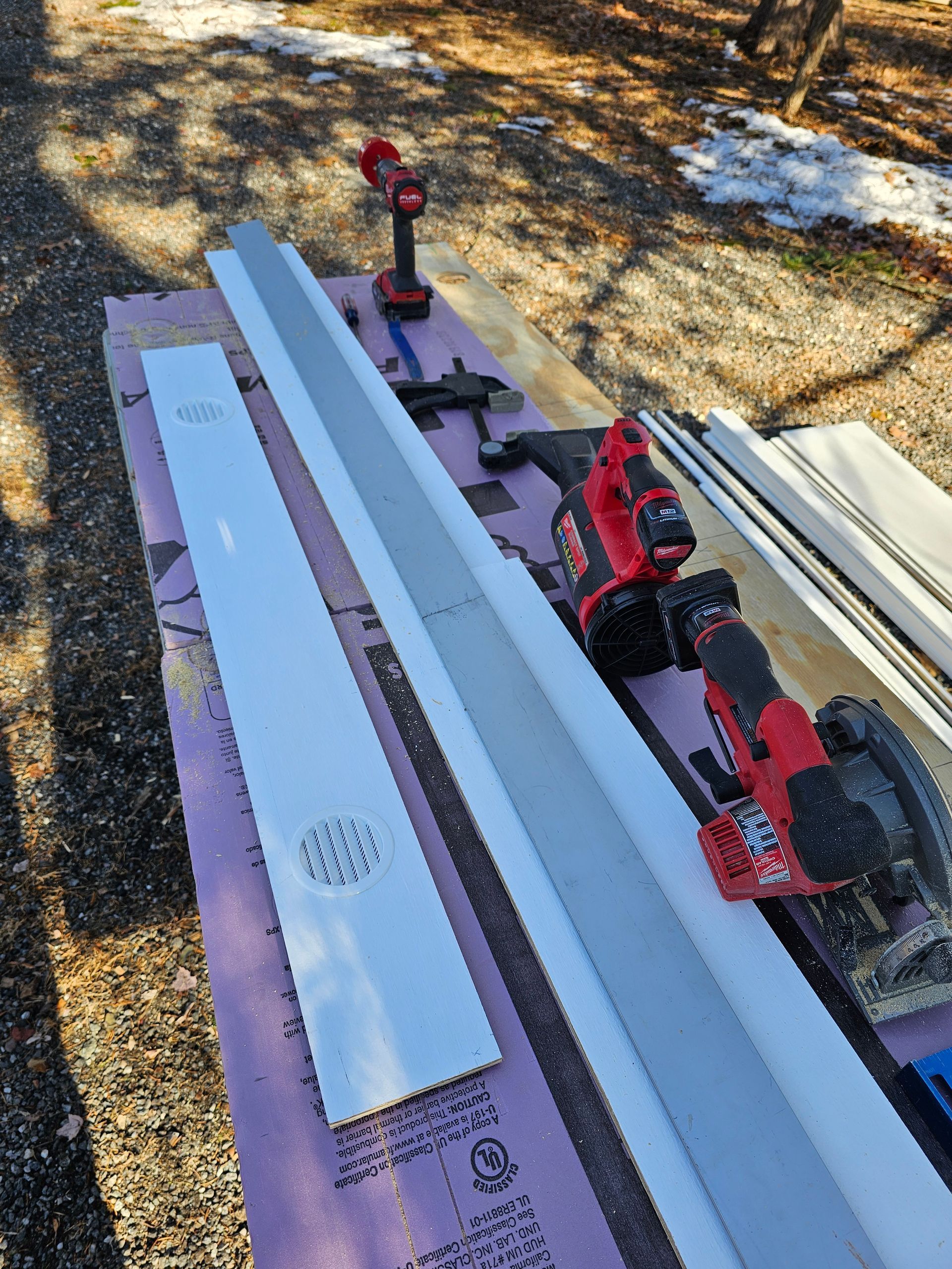 A circular saw is sitting on top of a table next to a piece of wood.