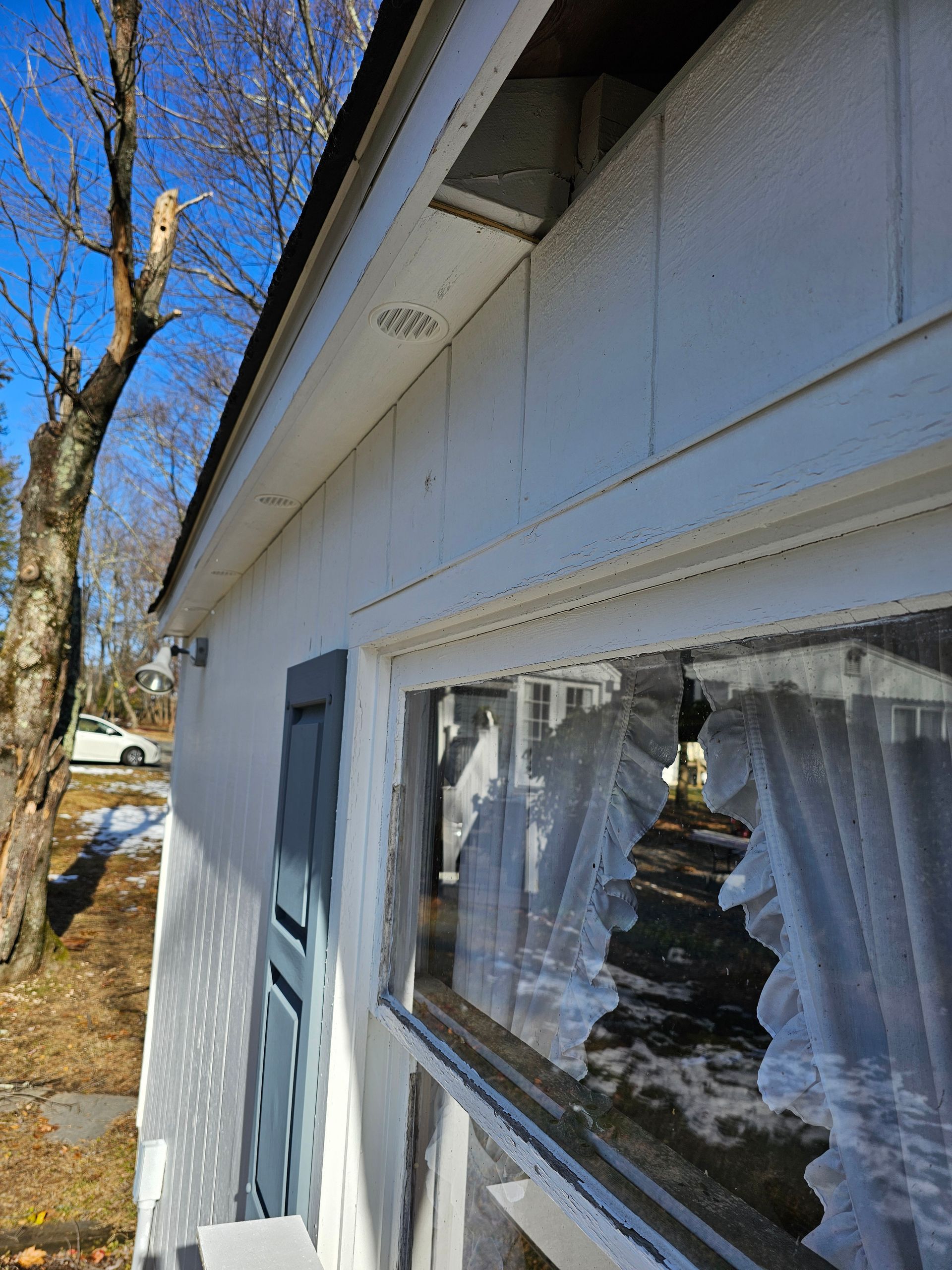A white house with a window and curtains on it