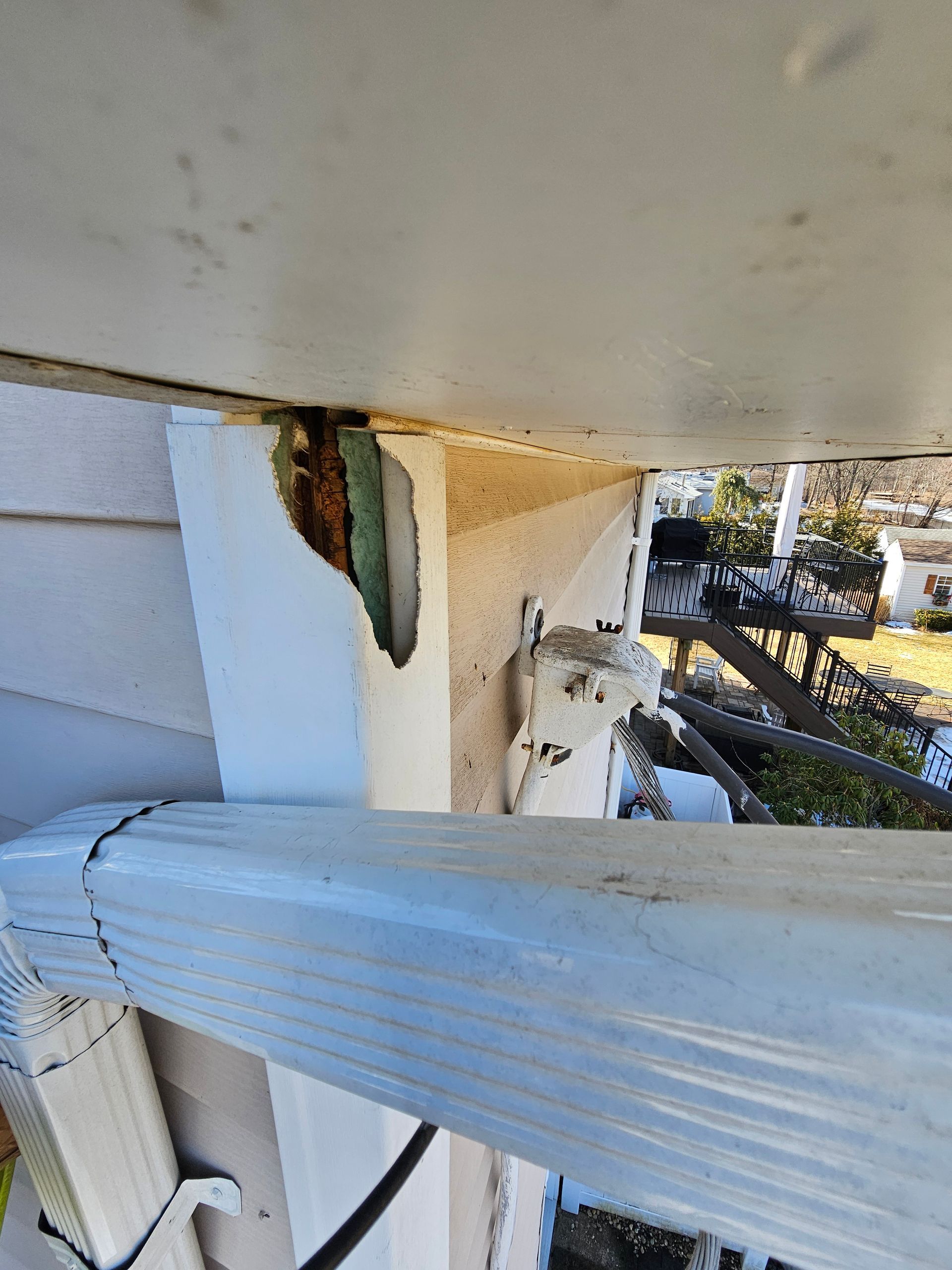A ladder is hanging from the side of a house.