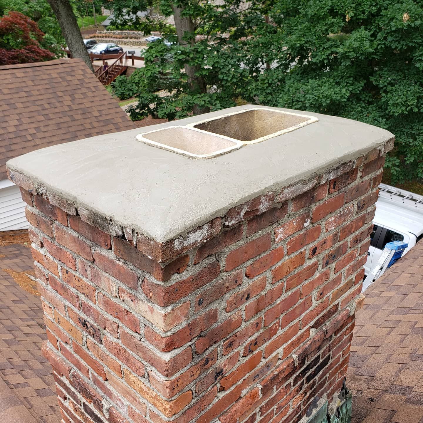 A brick chimney is sitting on top of a roof.