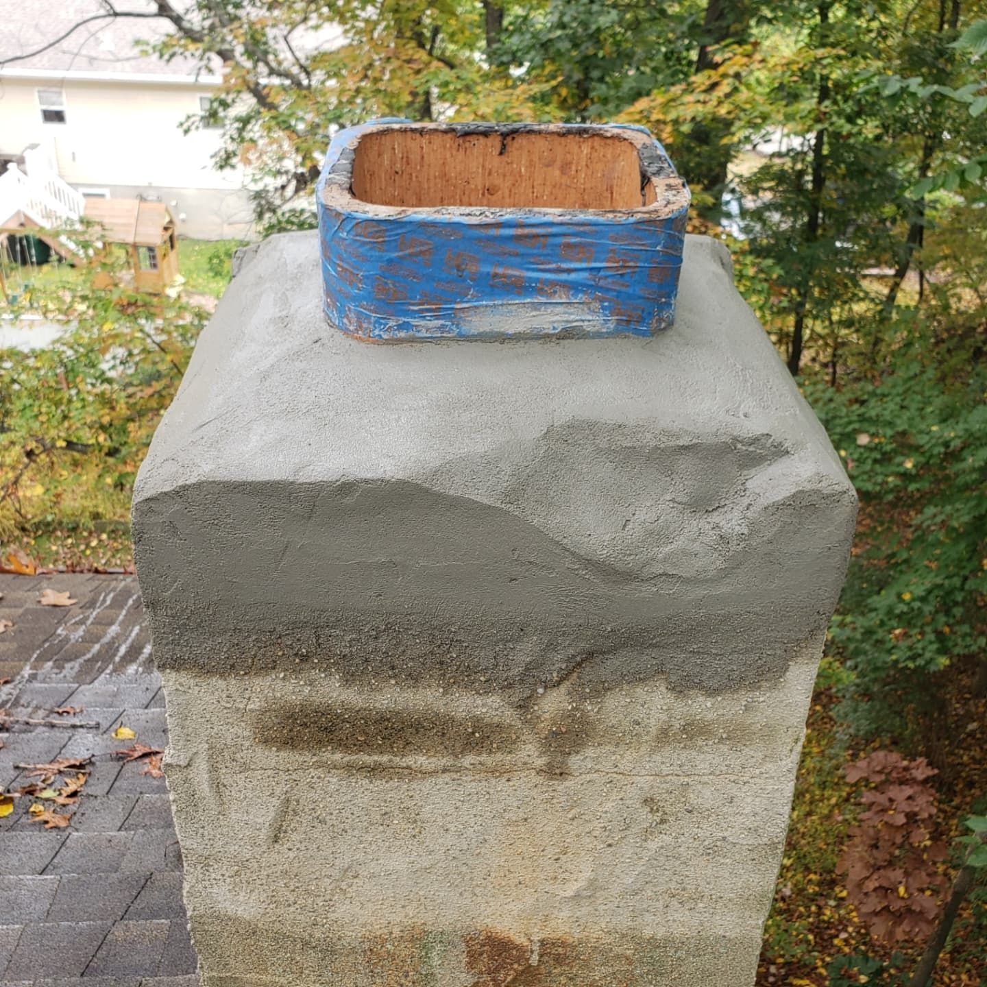 A chimney with a blue box on top of it.