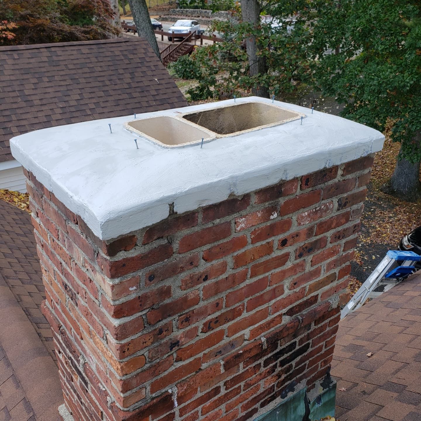 A brick chimney is sitting on top of a brick roof.