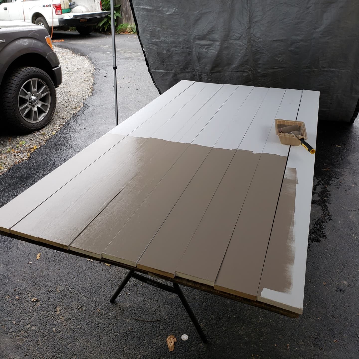 A wooden table is being painted with a brush