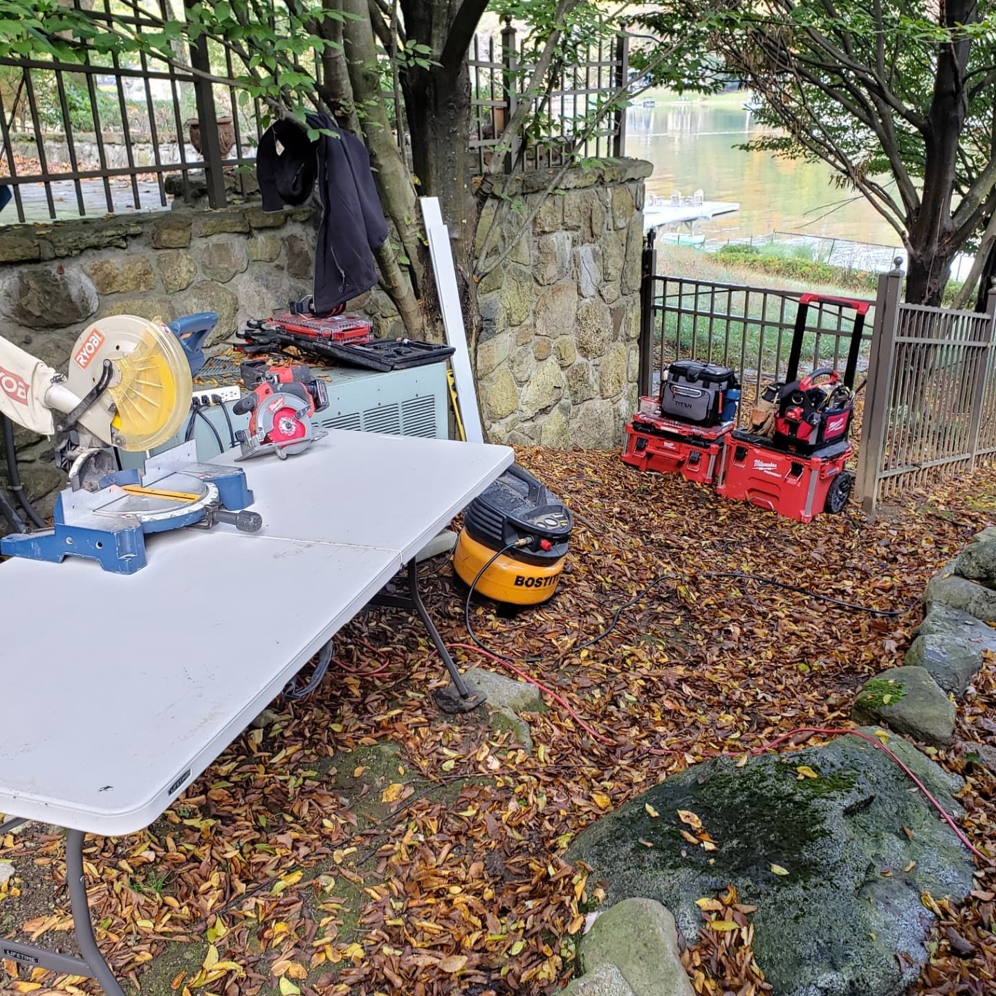 A table with a circular saw and a vacuum cleaner on it in a yard.