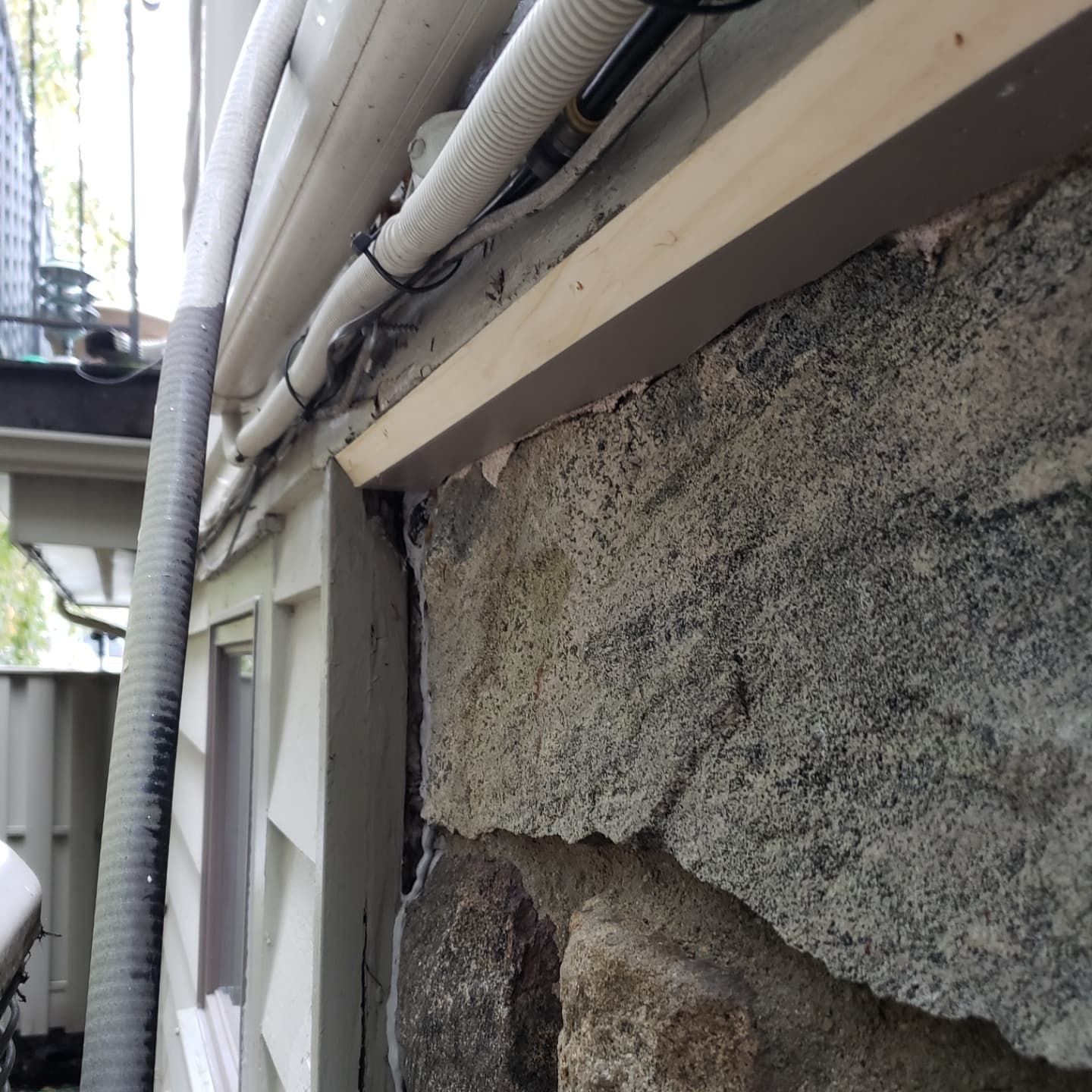 A stone wall with a hose attached to it