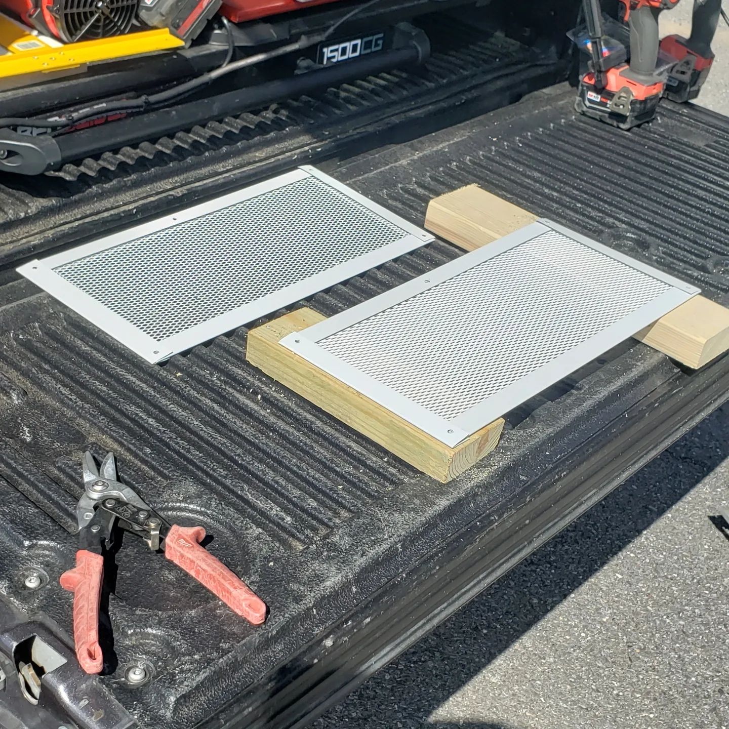 Two air vents are sitting on the back of a truck.