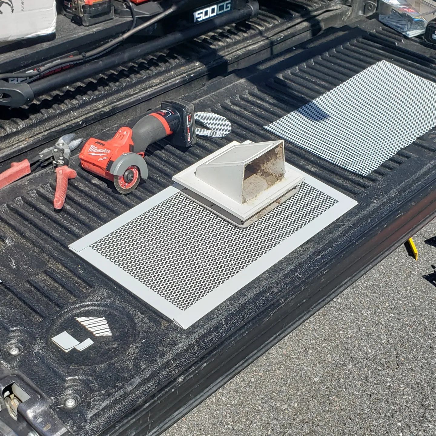 A truck bed with tools and a drill on it