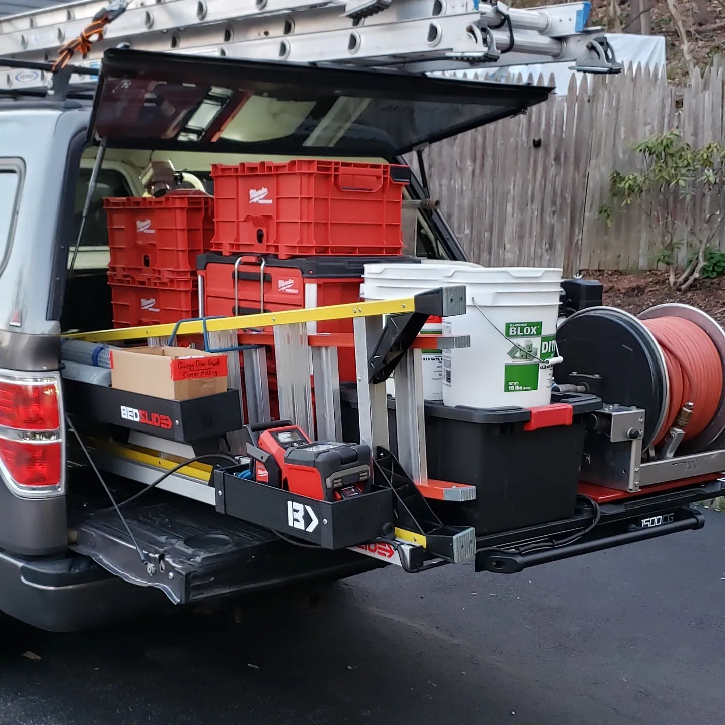 The back of a truck is filled with tools and boxes