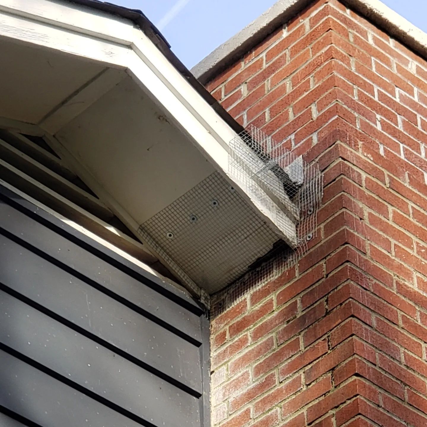 A brick chimney on the side of a house