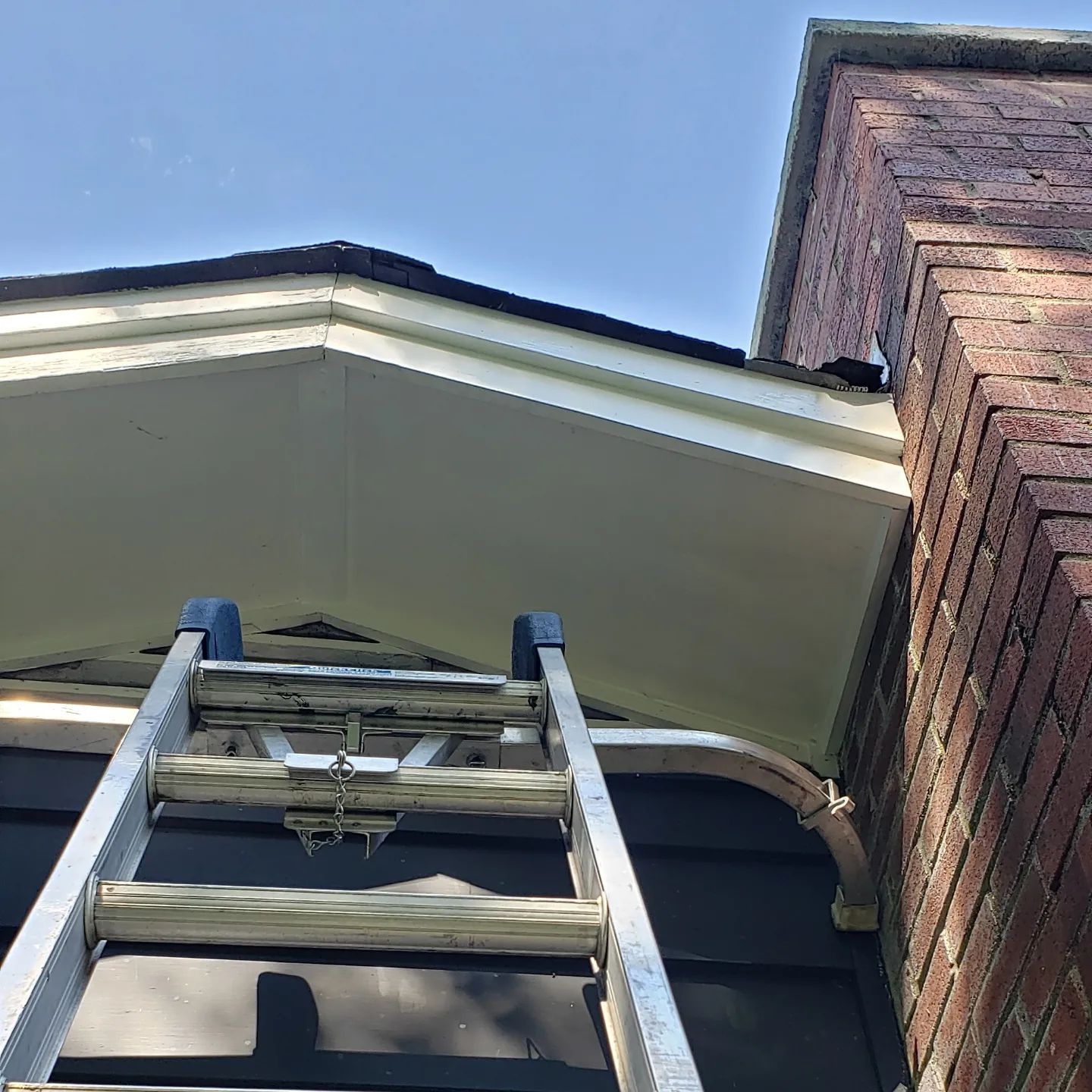 A ladder is attached to the side of a brick building.