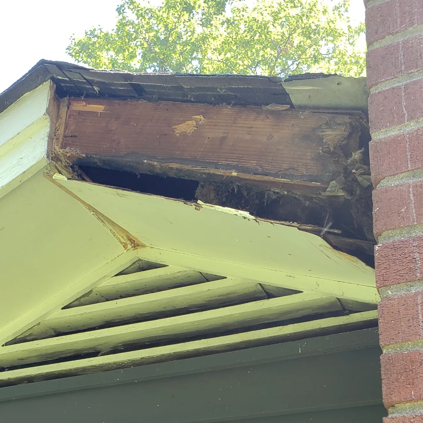 A house with a roof that is missing a piece of wood