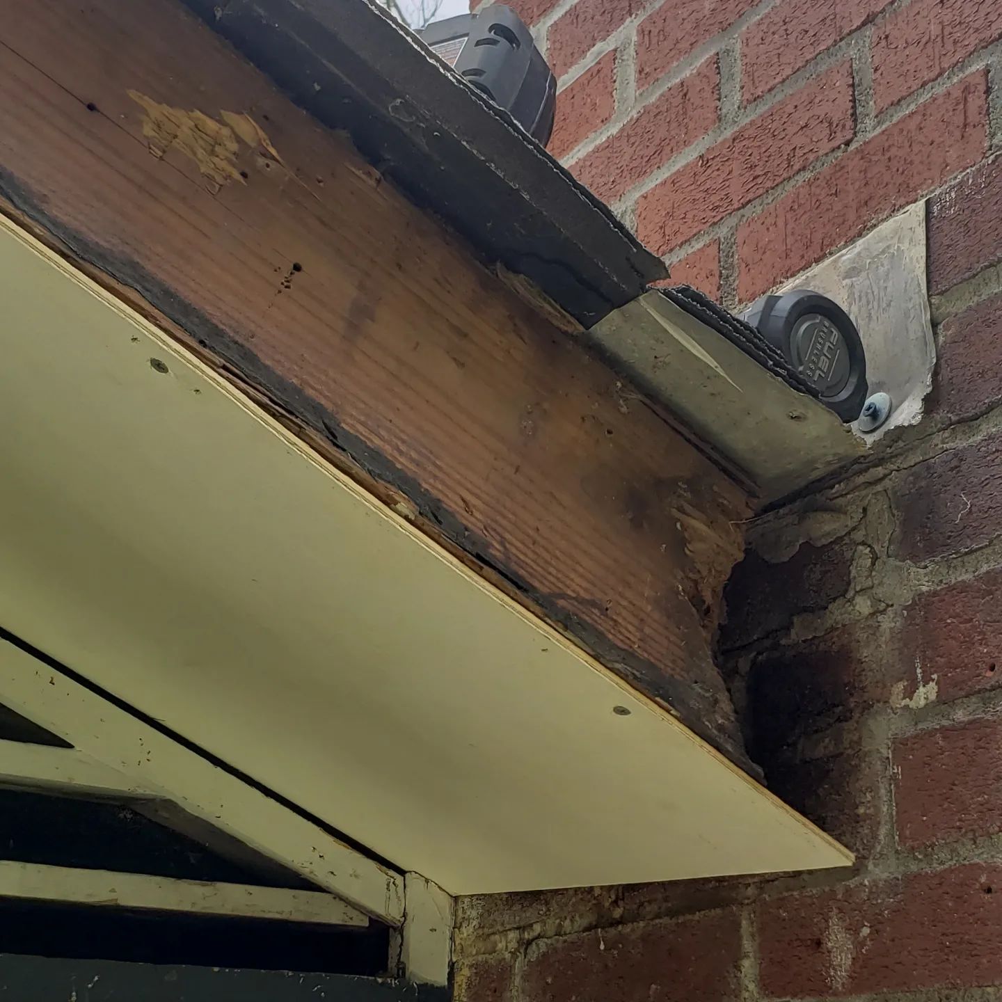 A brick wall with a wooden beam on top of it.