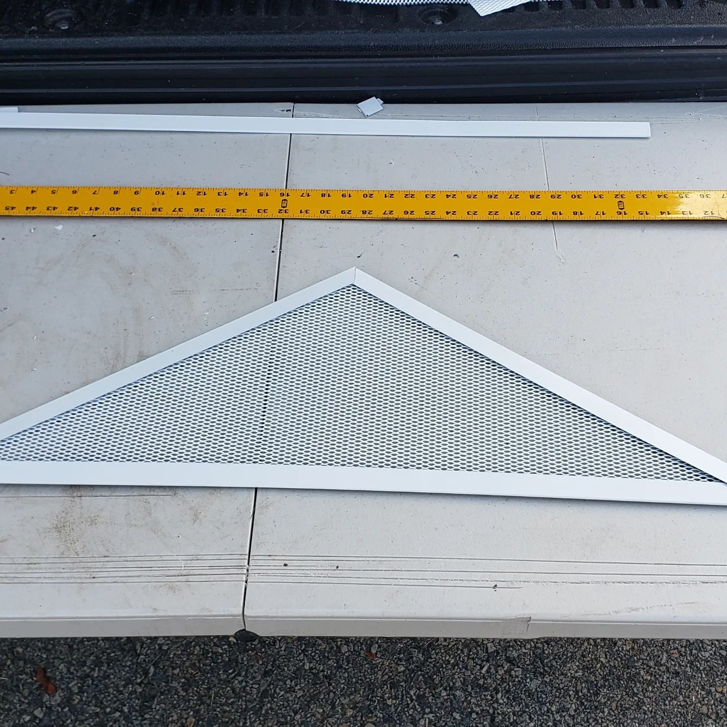 A metal triangle with a yellow ruler next to it