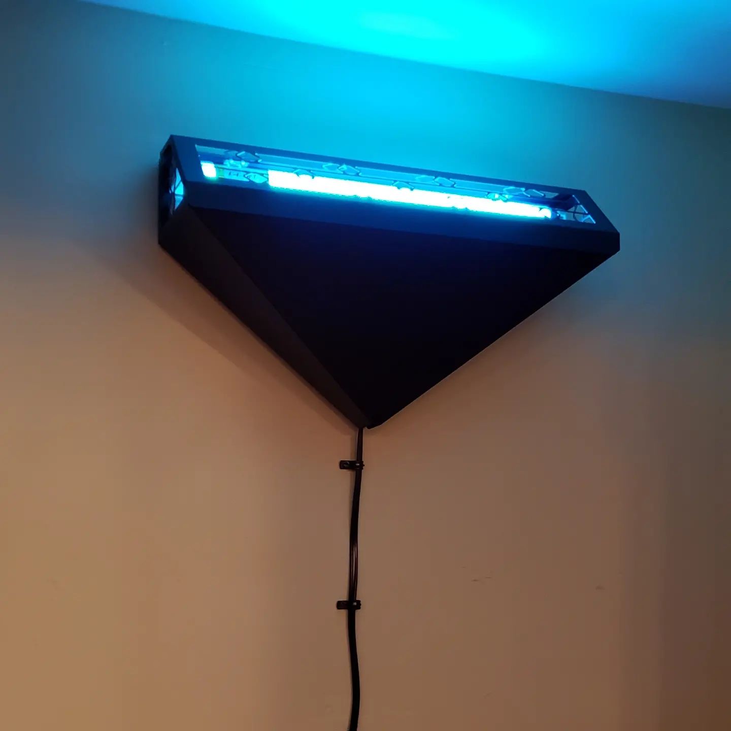 A triangle shaped light with a blue light coming out of it