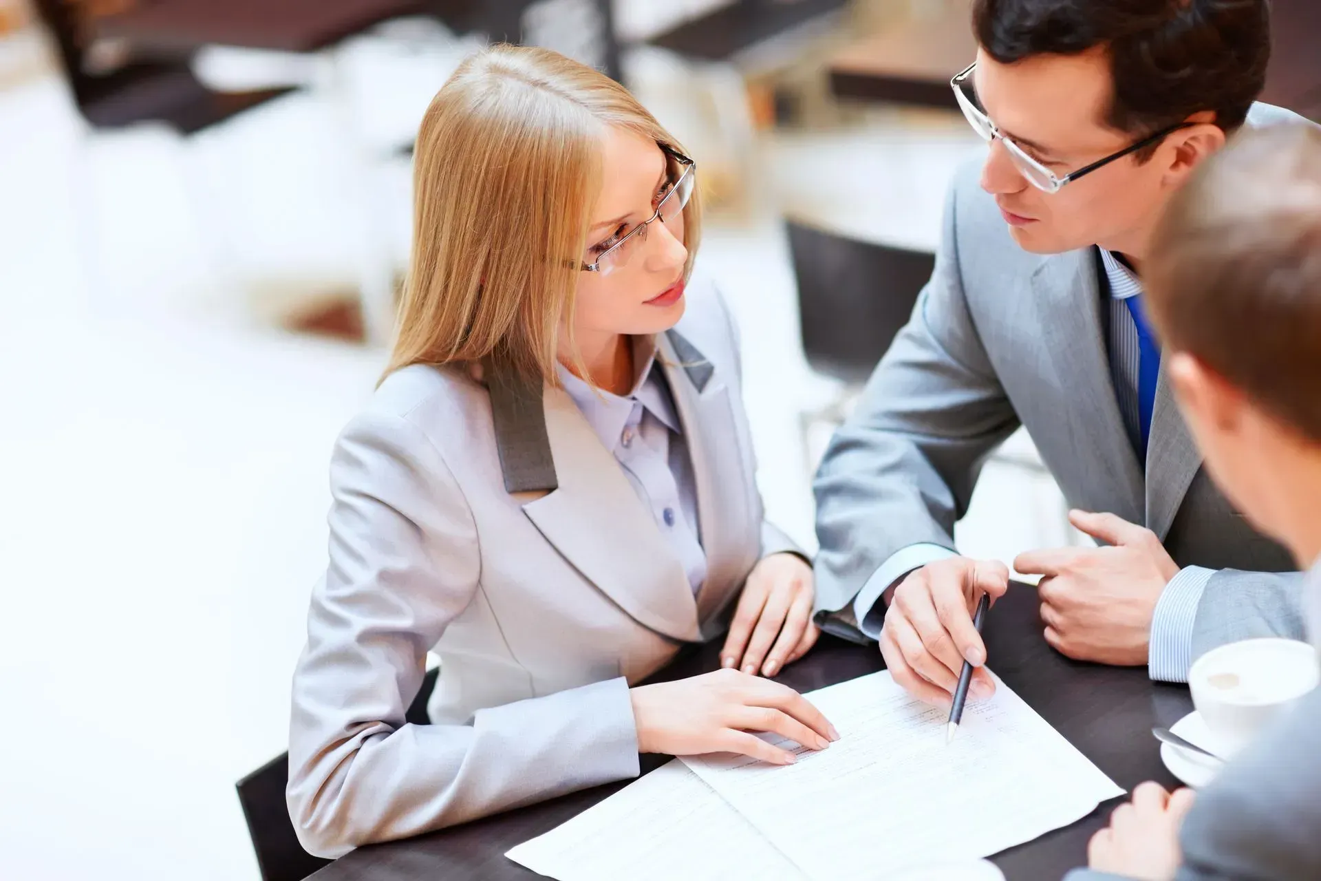 A group of people are sitting at a table looking at a piece of paper.