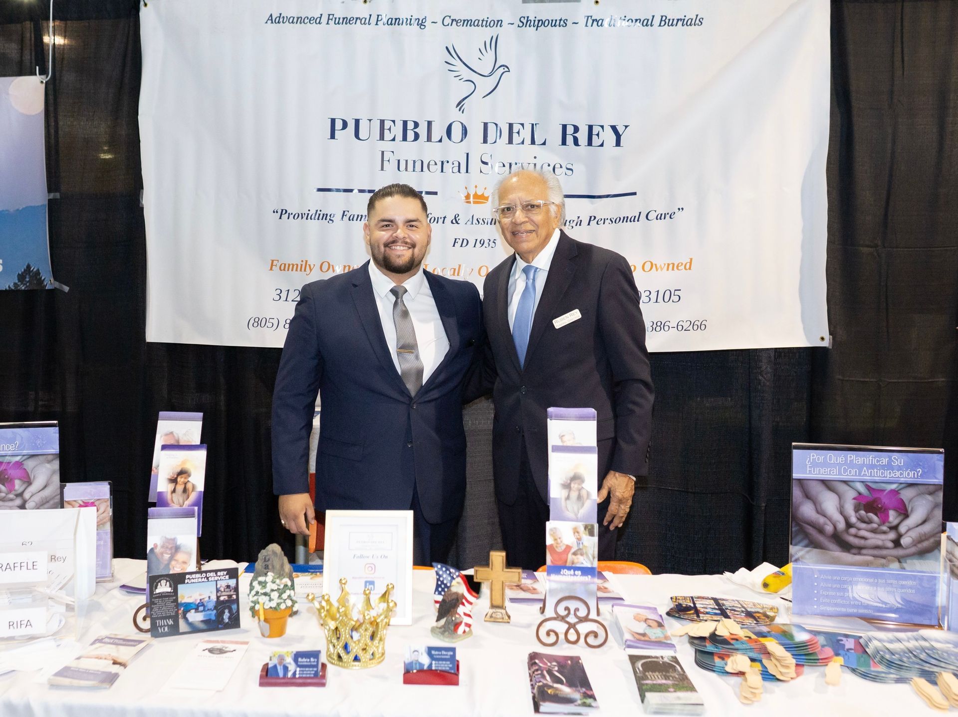 Fountain in a park with palm trees in the background under a cloudy sky.