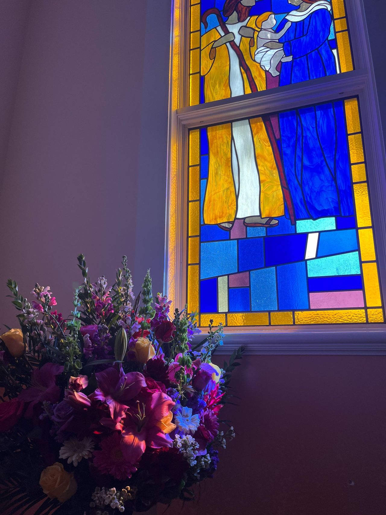 Aerial view of a sandy beach with turquoise waves crashing against it. Palm trees line the edge of the beach.