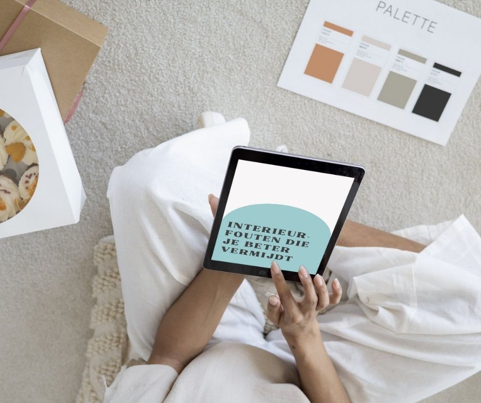 Persoon met tablet met tekst, palet en taartdoos op de vloer; interieurontwerpconcepten.