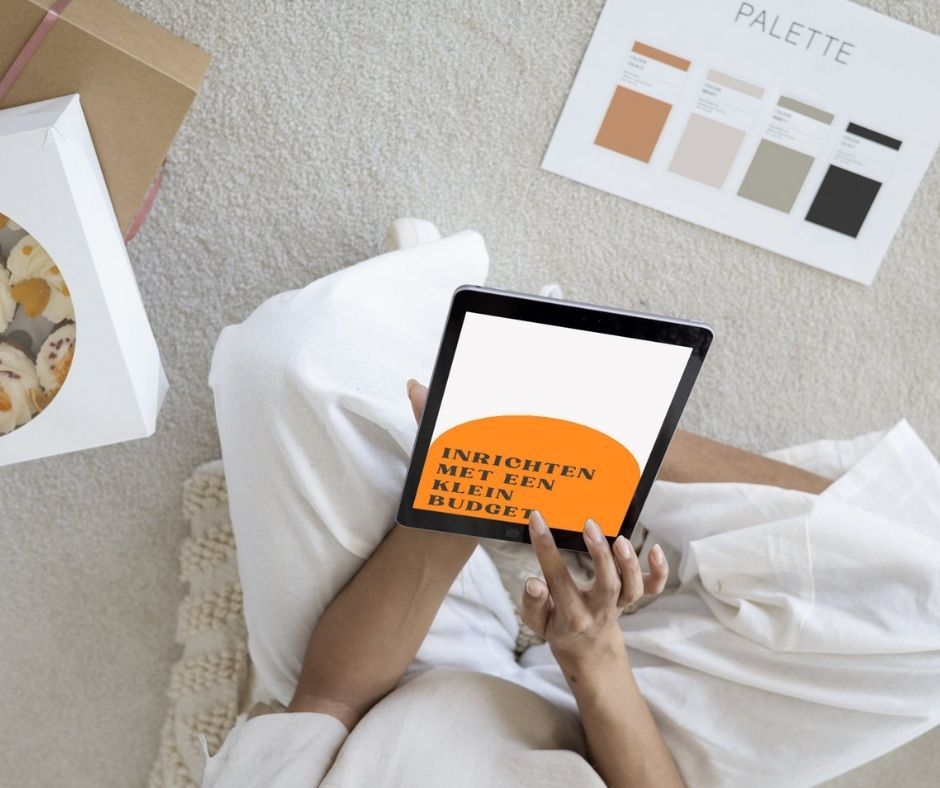 Person on a rug holding a tablet, displaying text: