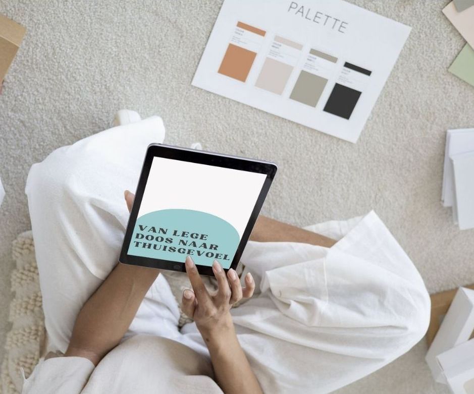 Persoon met tablet in de hand, zittend op tapijt, bekijkt een ontwerppalet.