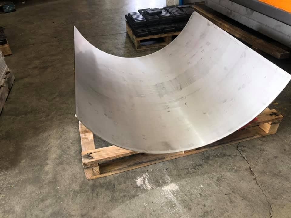 Bent sheet of metal sitting on a wooden pallet.