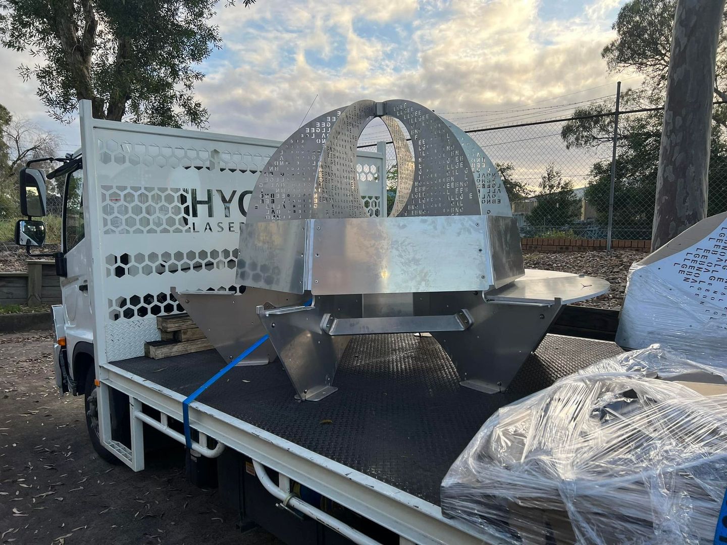 A white truck with a large metal object on the back of it.