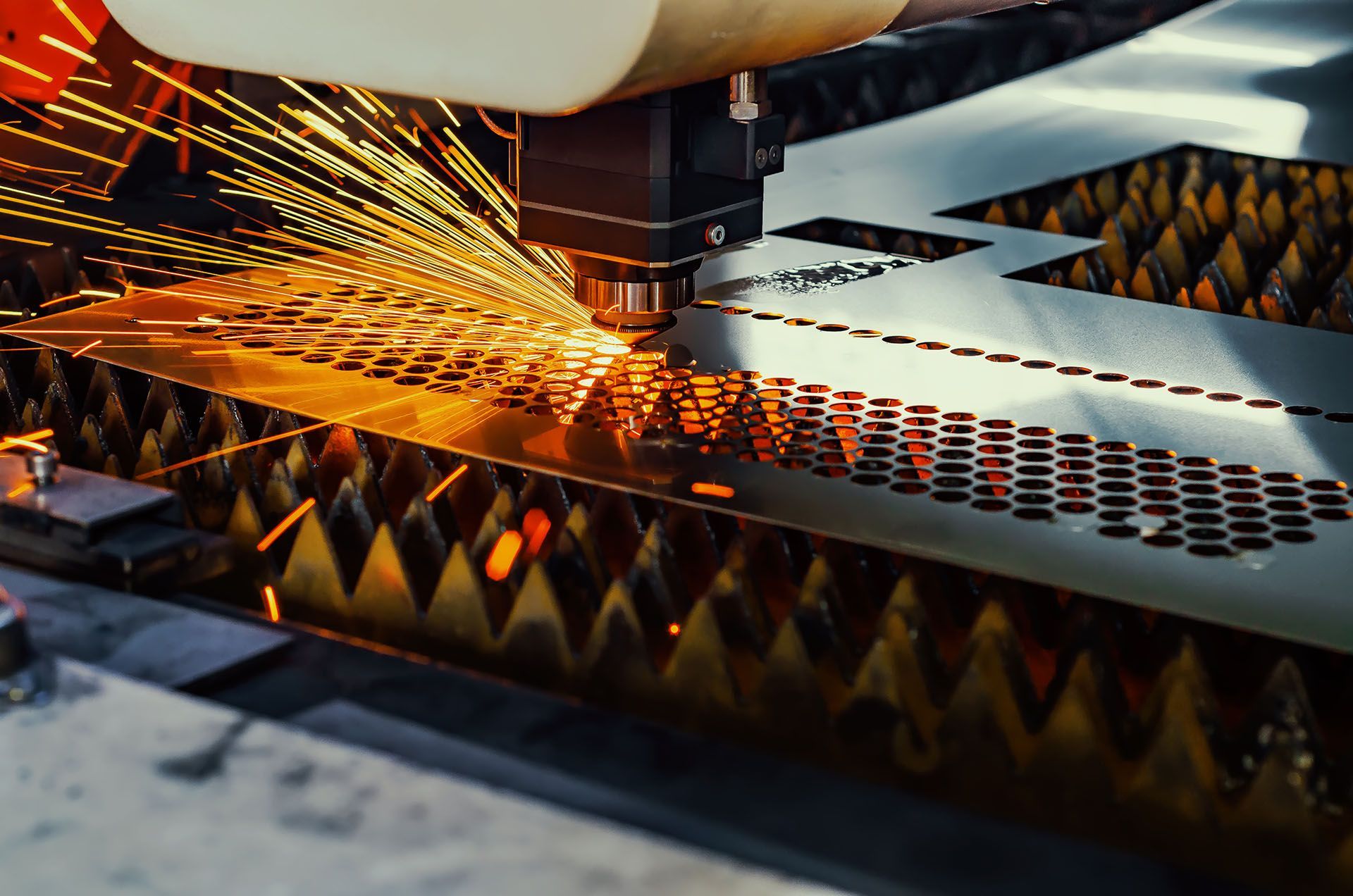 A machine is cutting a piece of metal in a factory