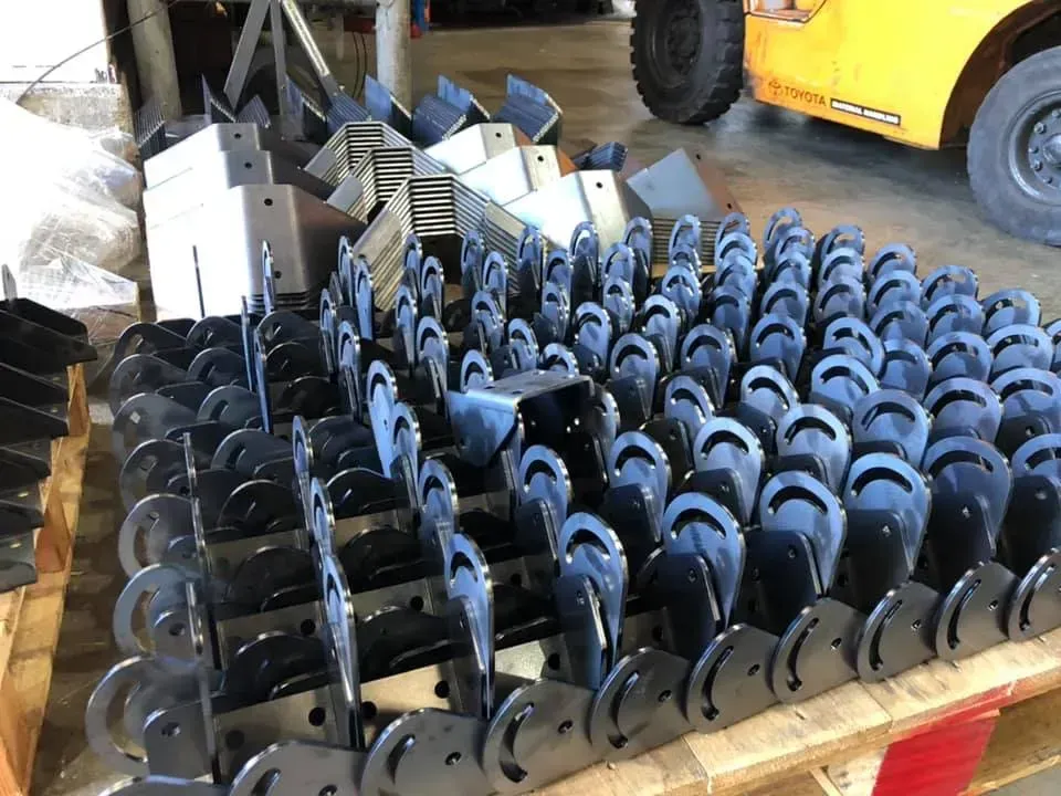 A bunch of metal pieces are sitting on top of a wooden pallet.