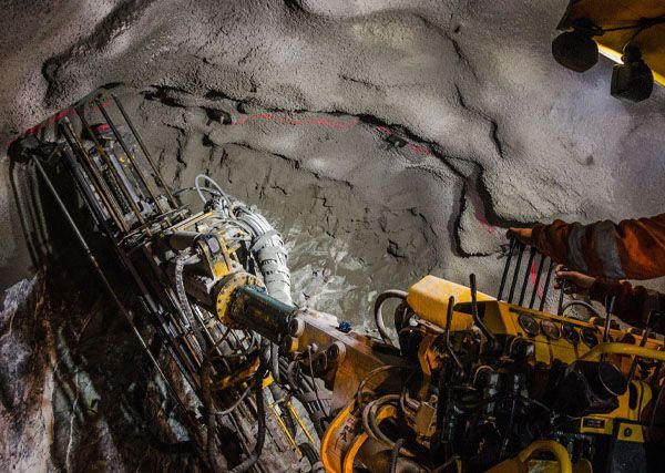 A man is working on a machine in a tunnel.