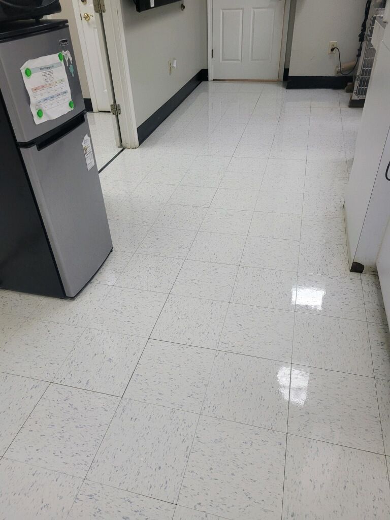 A kitchen with white tile floors and a refrigerator.