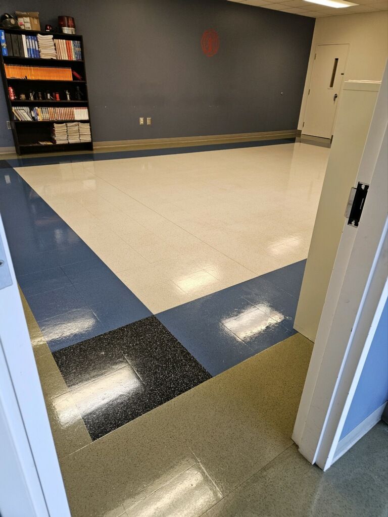 A hallway with a blue and white tile floor and a bookshelf.