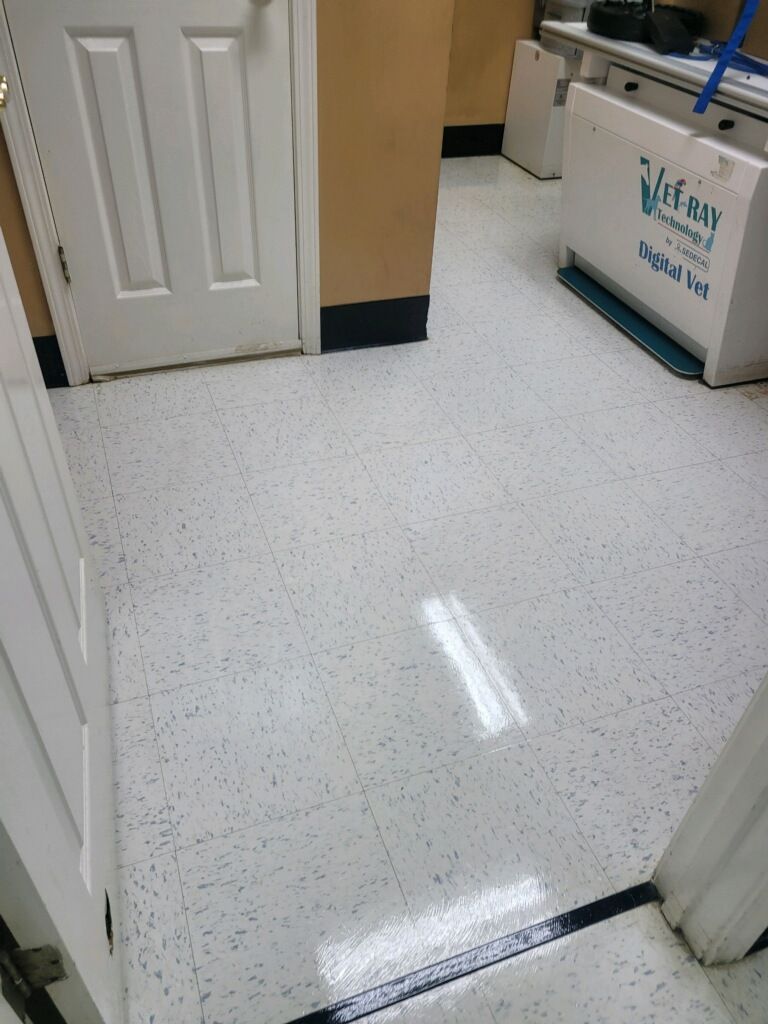 A white tile floor in a room with a door.