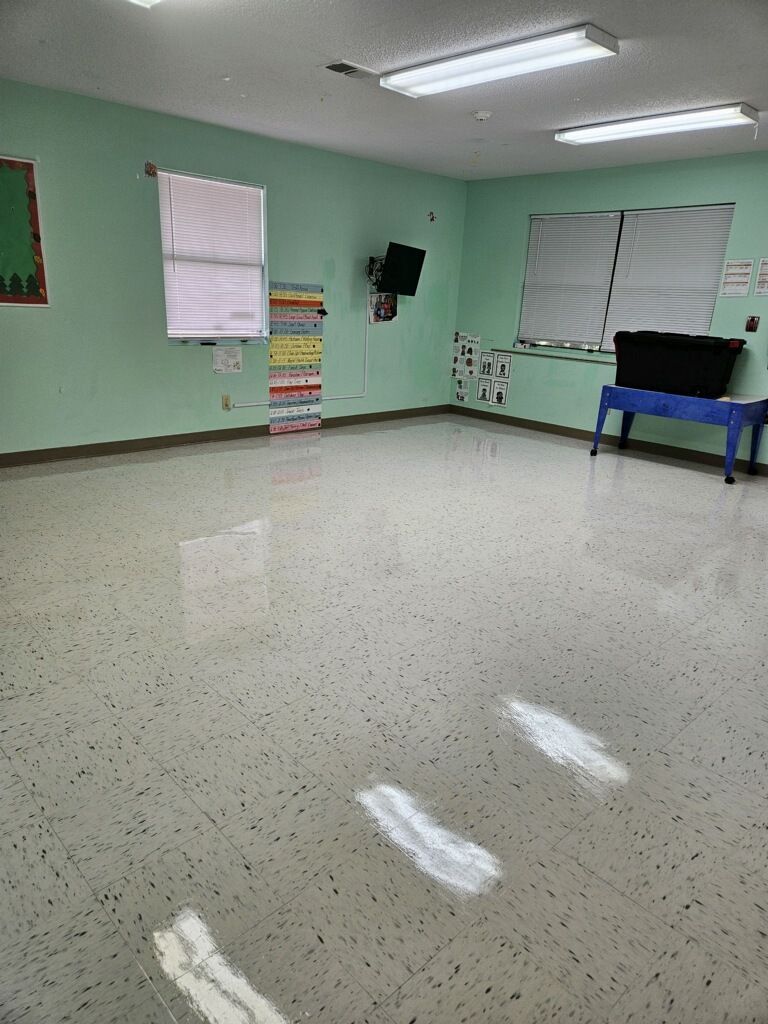 A large empty room with green walls and a shiny floor.