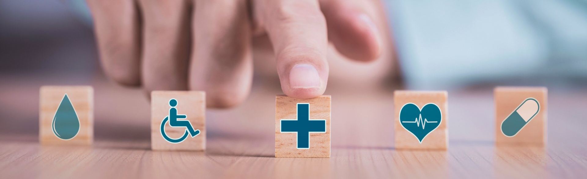 Man Chooses an Healthcare Medical Symbol on Wooden Block