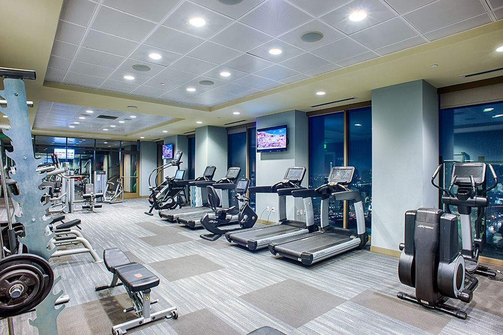 A large gym with a lot of treadmills and exercise bikes.