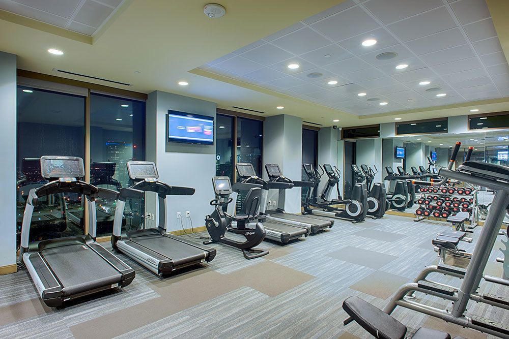 A gym filled with treadmills , exercise bikes , and a television.