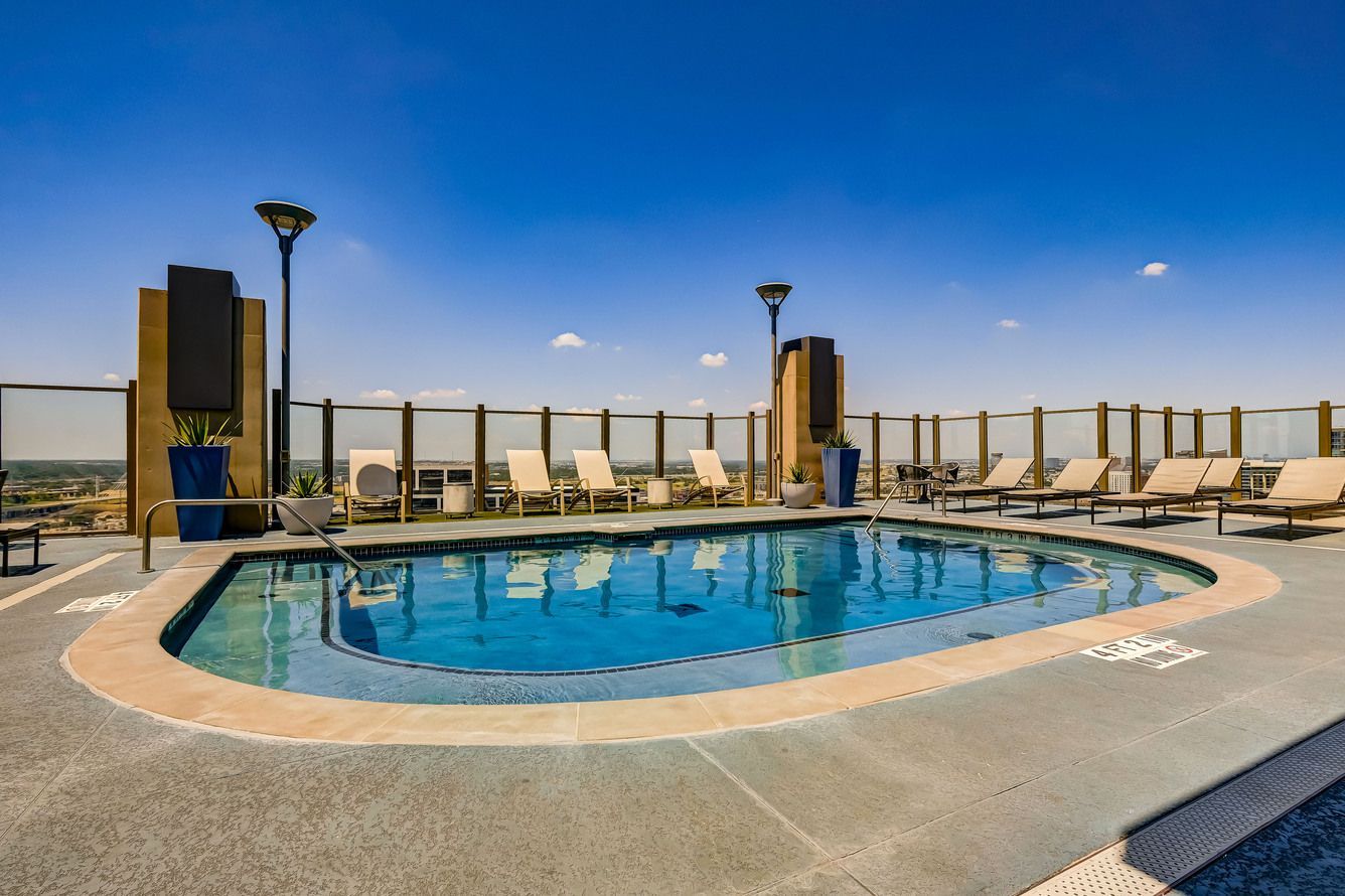 There is a large swimming pool on the roof of a building.