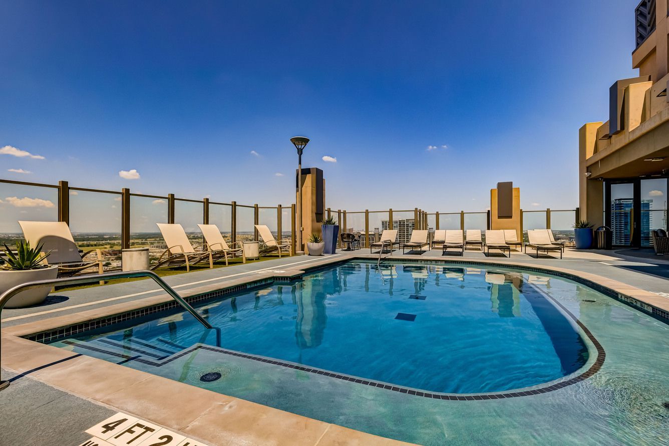 There is a large swimming pool on the roof of a building.